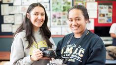 Two photography students holding cameras.